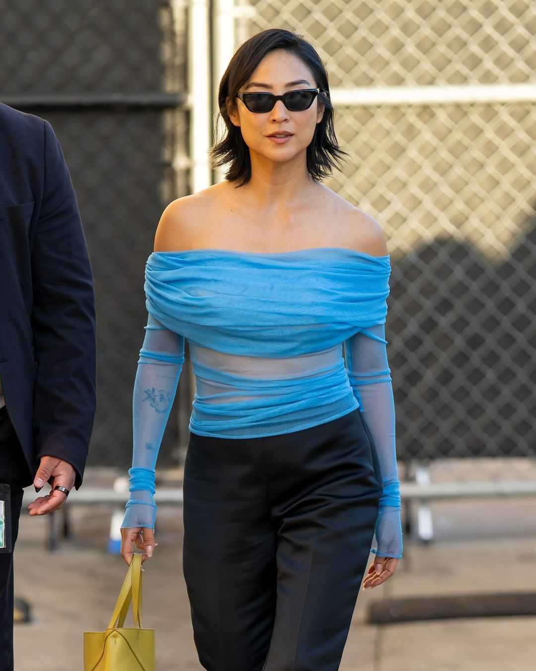 greta lee wearing blue top and black sunglasses outside