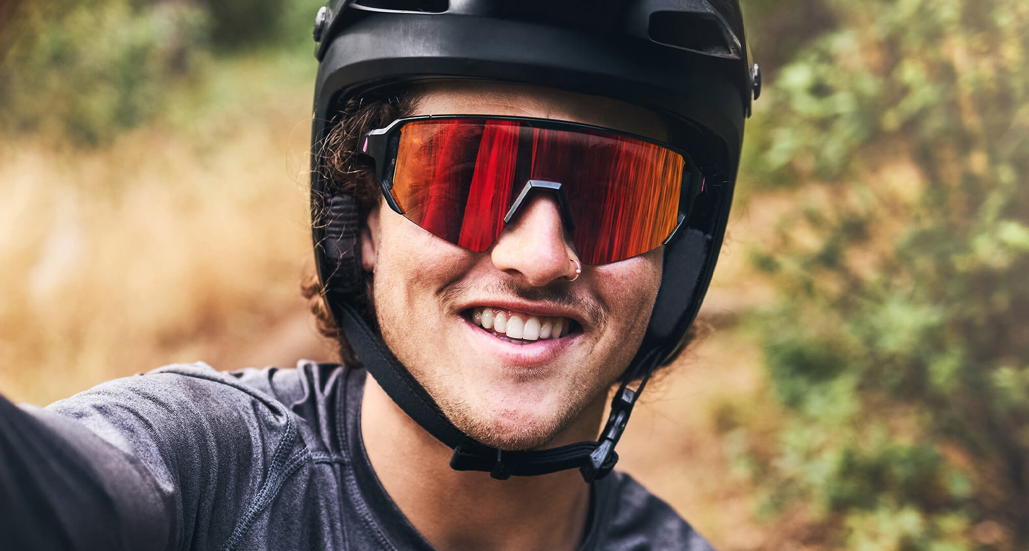 Nahaufnahme einer Person mit Fahrradhelm und Sonnenbrille